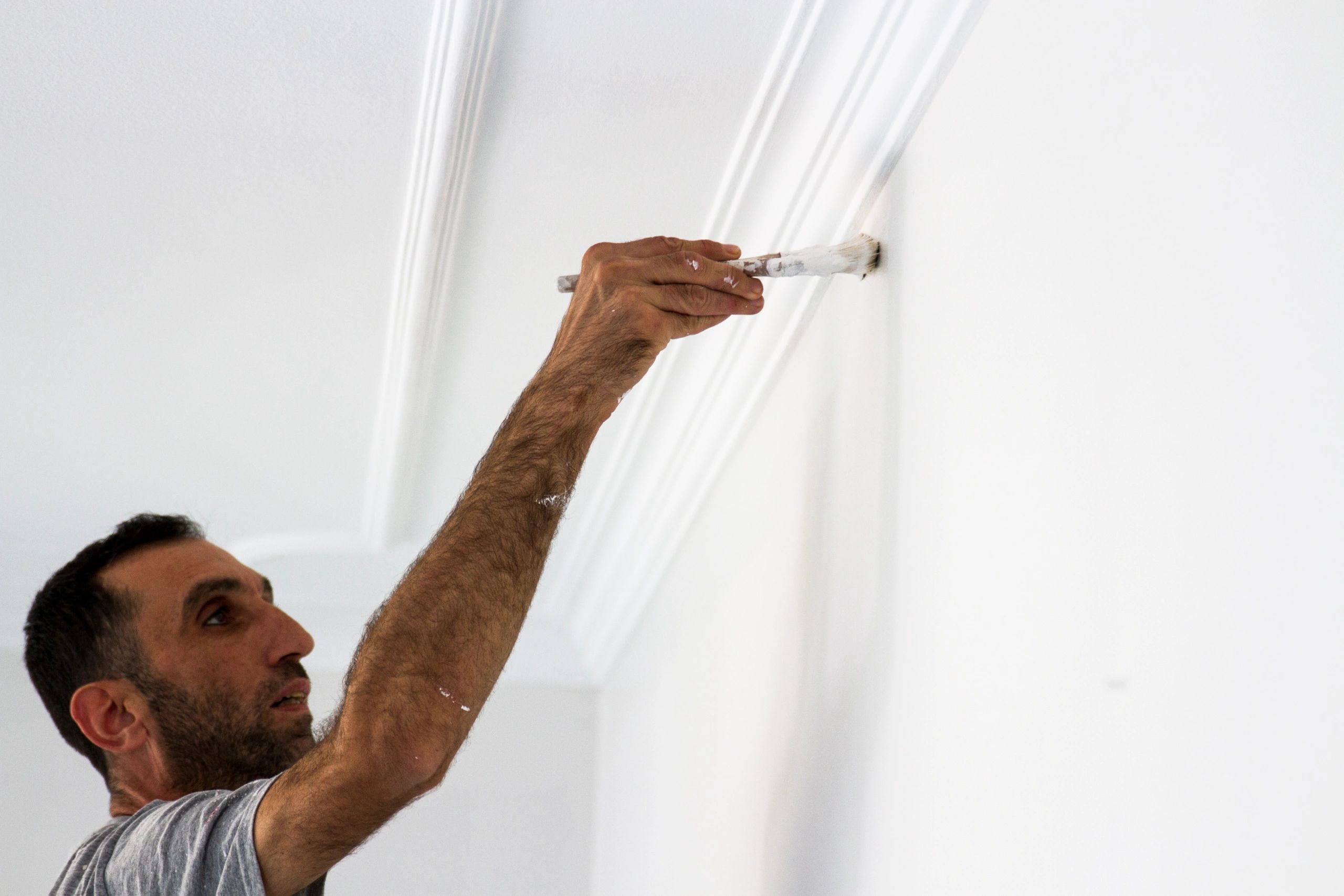 Painter cutting in along a ceiling edge