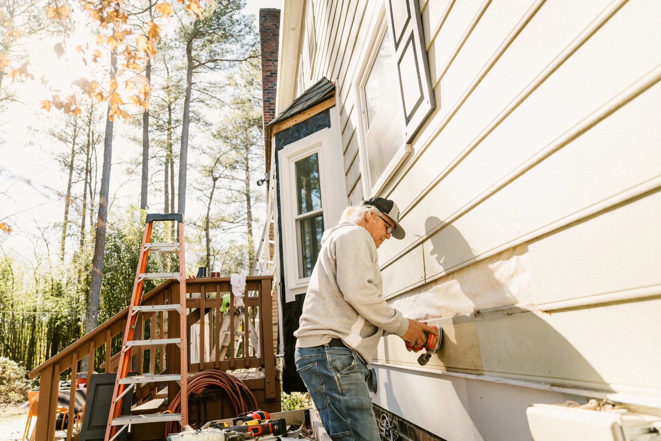 Worker repairing exterior siding before painting